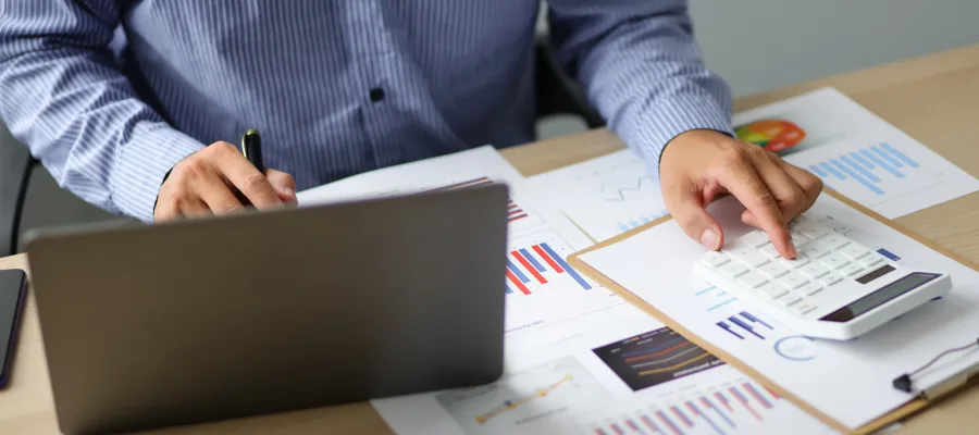 Accounting businessman working on laptop computer and analyzing real estate investment data, Financial accounting and tax systems concept.
